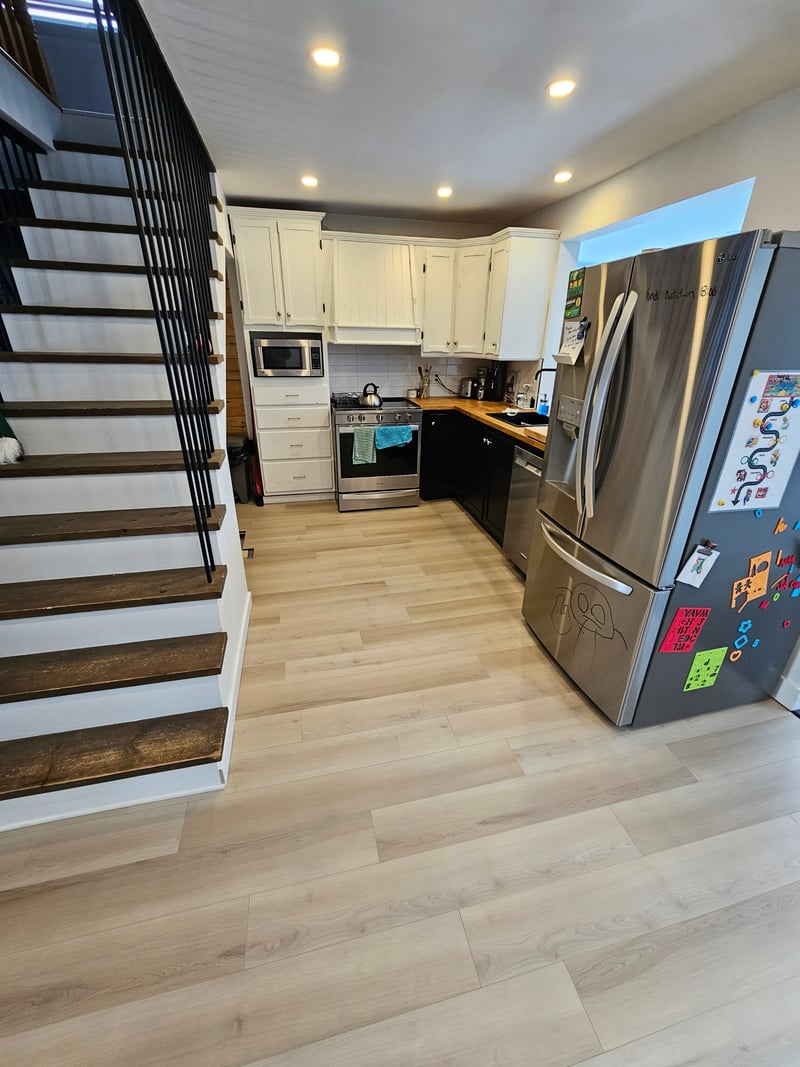 Cuisine blanche avec cuisinière, hotte encastrée et électroménagers en inox