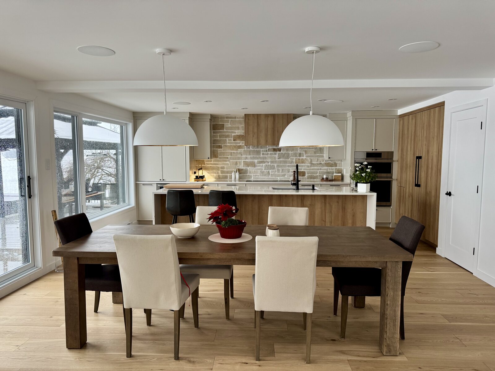 Cuisine rénovée avec îlot central, armoires en bois et salle à manger attenante
